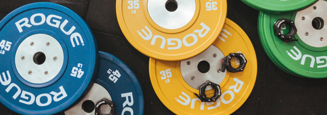 Blue, yellow, and green weights lined up on gym floor