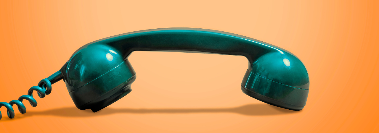 orange background with green corded telephone in foreground