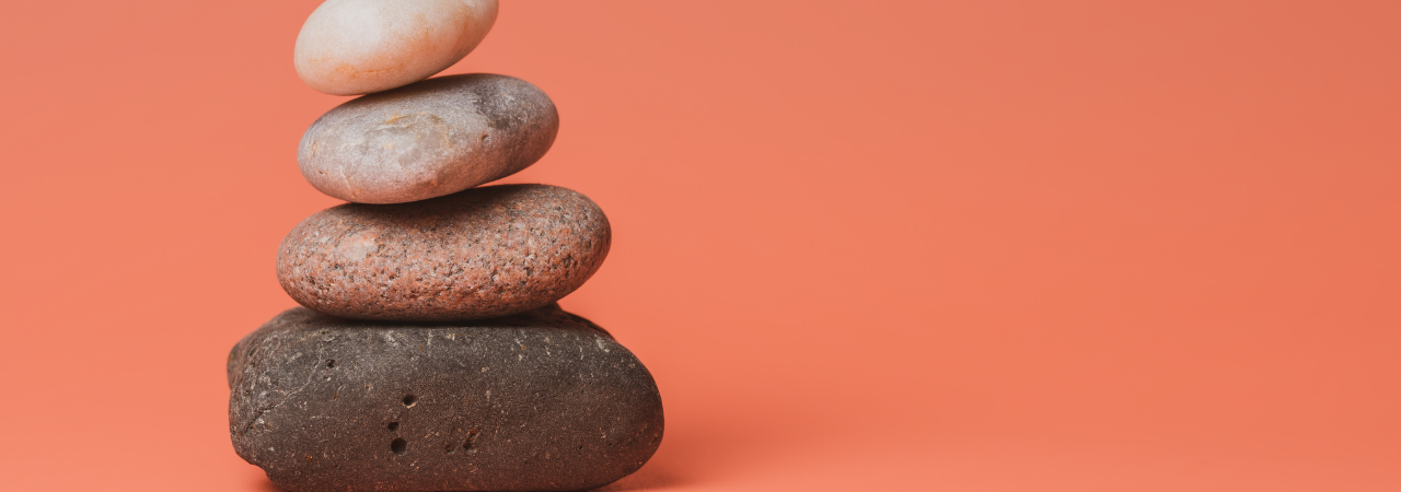 coral orange background with four rocks getting smaller piled into stack