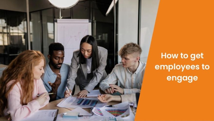 Group of young employees gather around a table discussing and planning with overlay of blog title 'how to get employees to engage'