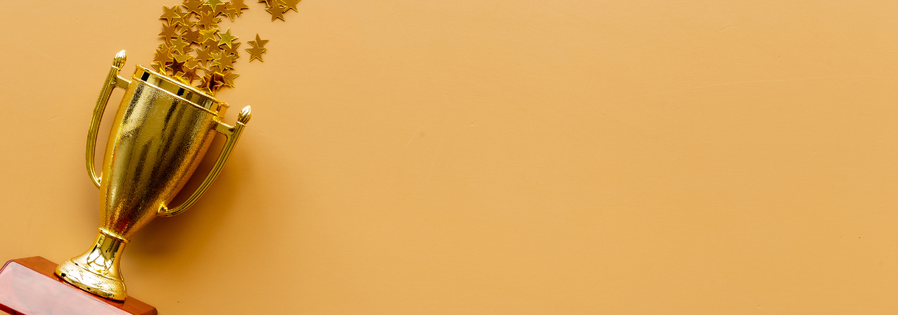 gold trophy lays against orange background, spilling gold stars confetti