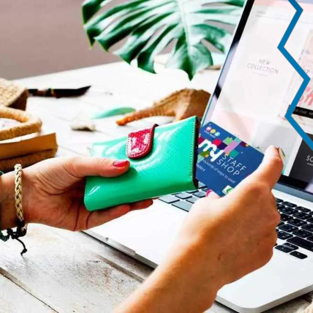 hands pulling My Staff Shop gift card out of purse in front of laptop screen