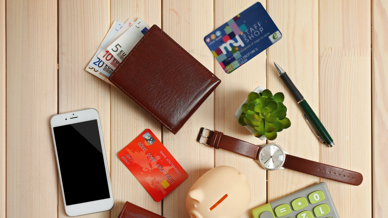 A flatlay of a table with items such as watch, calculator, purse and the Love2shop discount card